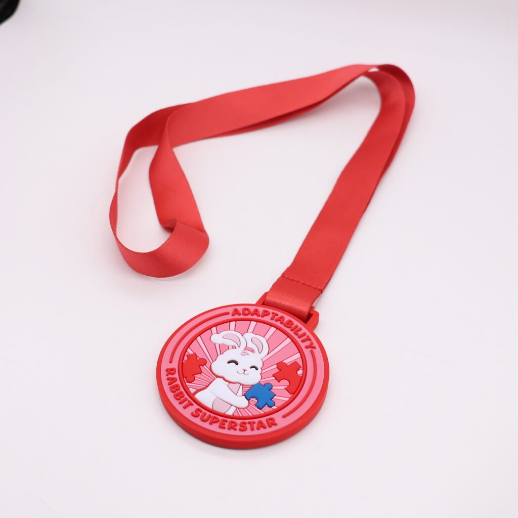 Custom red PVC medals featuring a smiling white rabbit holding a blue puzzle piece; inscribed with "ADAPTABILITY" and "RABBIT SUPERSTAR"; paired with a red ribbon for children's events or fun runs.