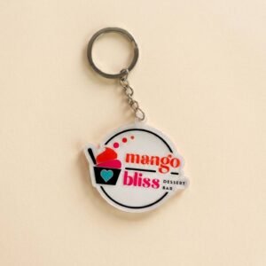 Custom Acrylic Keychain Mango Dessert Shop Logo Charm Round acrylic keychain featuring "mango bliss" lettering and a mango ice cream sundae illustration in a red, yellow, and pink contrasting color design, with a metal chain attached, displayed on a pure white background