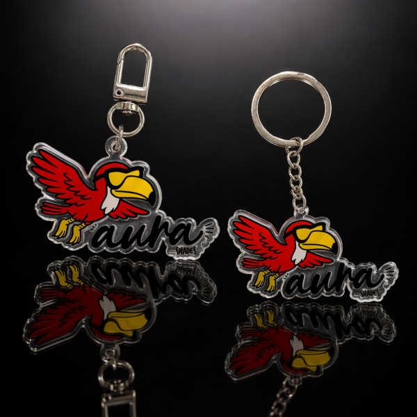 Custom double-sided clear acrylic keychain featuring a red toucan graphic and black "aura" typography; encapsulated in clear epoxy resin with a smooth polished edge, fitted with a metal lobster clasp and split ring for bags, keys or promotional merchandise.