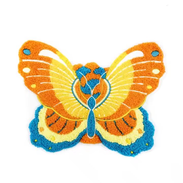 Colorful layered butterfly chenille patch with an orange body accented by yellow and blue gradient edges and white vein outlines, displayed on a pure white background, with a dimensional plush texture