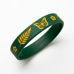 Dark green epoxy bracelet with gold-tone butterfly, wheat ear leaves, and small flower motifs embedded on the surface — a vintage contrasting-color design with a glossy finish — displayed on a pure white background