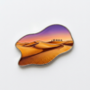 Premium metal fridge magnet featuring a desert sunset landscape with purple-to-orange gradient sky, golden sand dune textures, camel caravan silhouettes, and silver metal trim, displayed on plain white background.