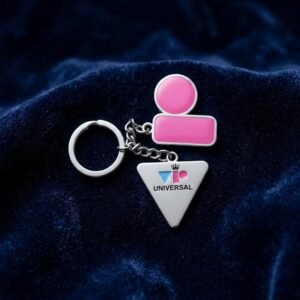 Custom metal keychain with pink human figure charm and silver triangle pendant featuring 'VIP Universal' logo on blue velvet background