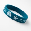Custom blue silicone wristband featuring white ocean element graphics (shell, starfish, wave lines) printed on the surface with a solid-color interior, on a pure white background