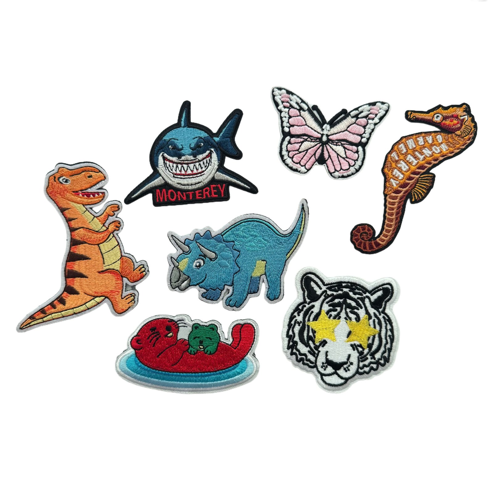 Colorful custom embroidered character patches arranged on a white background