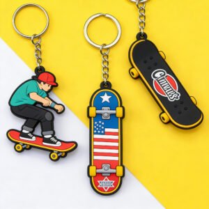 A set of three skateboard-themed custom PVC keychains. The left features a cartoon boy skateboarding, the center displays a skateboard deck with the American Stars and Stripes flag pattern, and the right shows a black skateboard with "Chums" text and a red lip print. All use 3D epoxy doming, vibrant colors, and silver metal key rings.