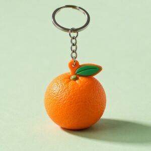 A lifelike 3D orange-shaped PVC soft rubber keychain featuring a vibrant orange peel texture, green stem and leaf detail; attached via a short metal chain to a standard silver split ring, offering a playful and tactile accessory.