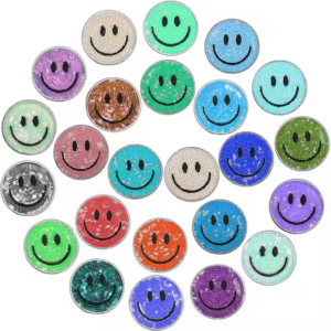Assorted colorful round smiley face sequin embroidered patches featuring double-sided reversible sequins that shift color with a gentle swipe; classic minimalist smiley design with color-matched merrowed edges, backed with heat-seal adhesive for creative DIY embellishment on t-shirts, jeans, hats or backpacks.